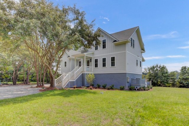 view of front of house with central AC and a front lawn