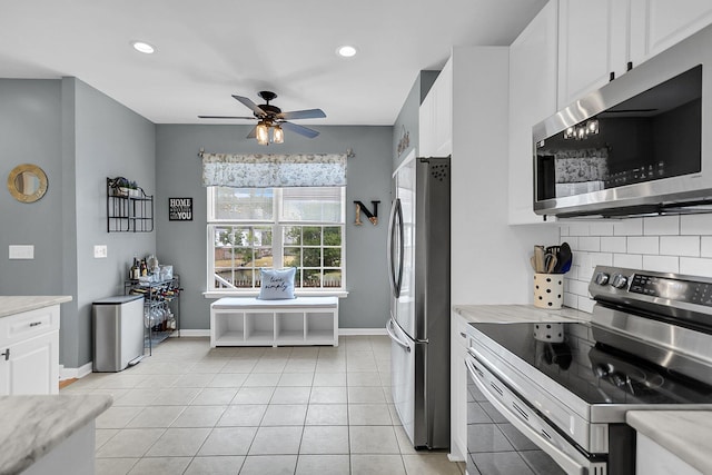 kitchen featuring light tile patterned floors, light countertops, appliances with stainless steel finishes, white cabinetry, and tasteful backsplash