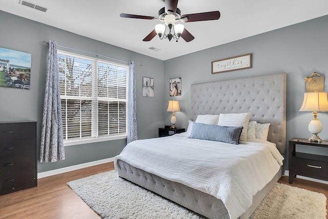 bedroom with visible vents, ceiling fan, baseboards, and wood finished floors