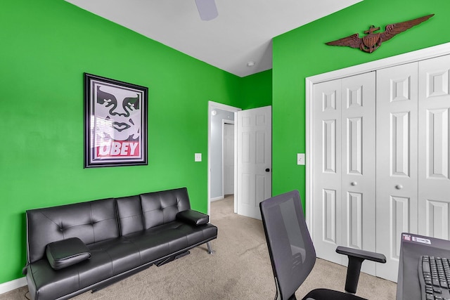 carpeted home office featuring an accent wall and baseboards