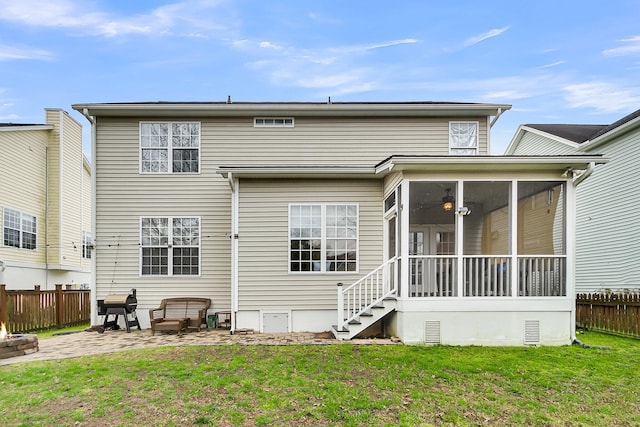 rear view of house featuring a patio, a lawn, fence, and a sunroom