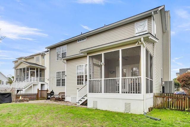 rear view of property with stairs, a yard, fence, and a sunroom