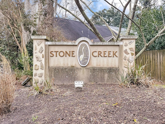 community / neighborhood sign featuring fence