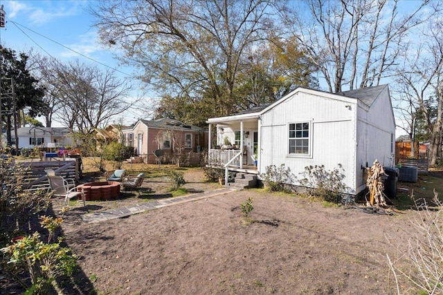 exterior space with covered porch and an outdoor fire pit