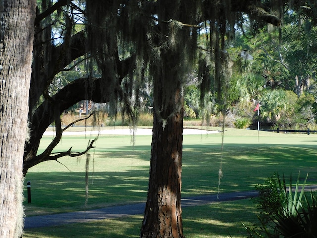 view of tennis court featuring a yard and basketball hoop