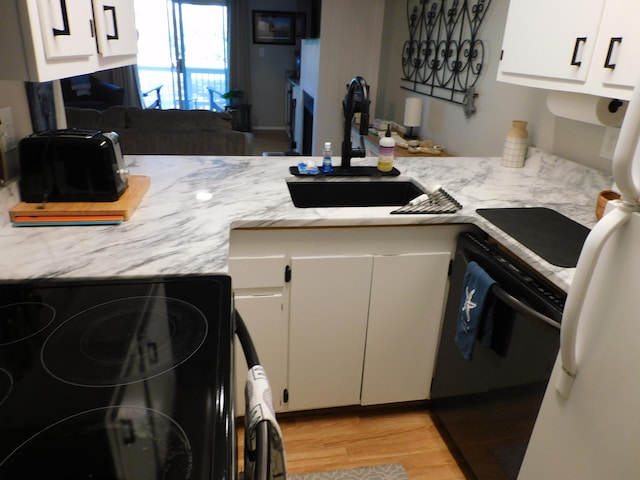 kitchen with white cabinets, light hardwood / wood-style floors, range, and sink