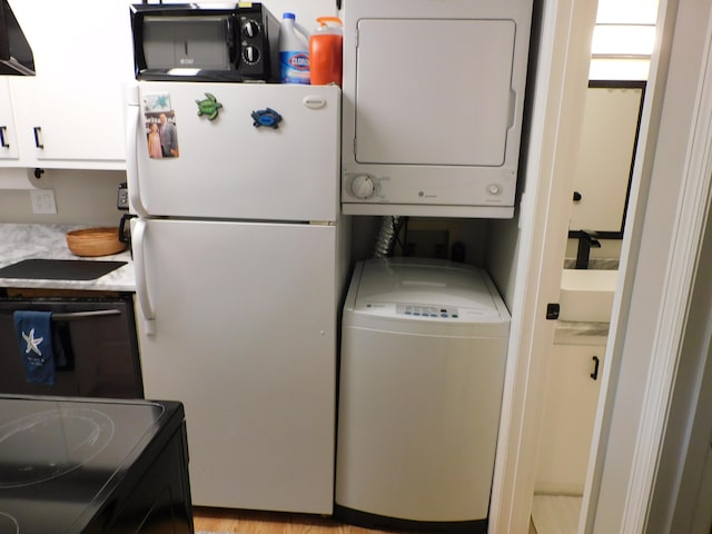 clothes washing area with stacked washer / dryer and light wood-type flooring