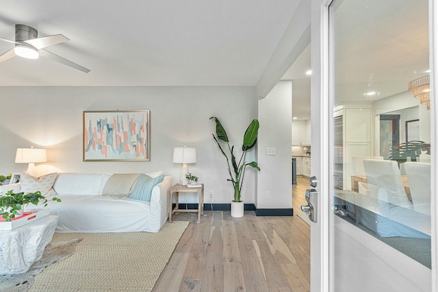 living room with light hardwood / wood-style floors and ceiling fan