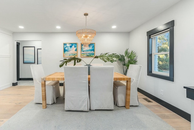 dining area with a chandelier and light hardwood / wood-style flooring