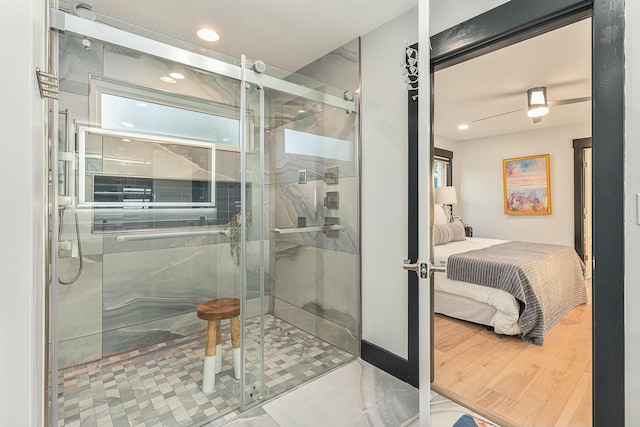 bathroom with hardwood / wood-style floors and a shower with shower door