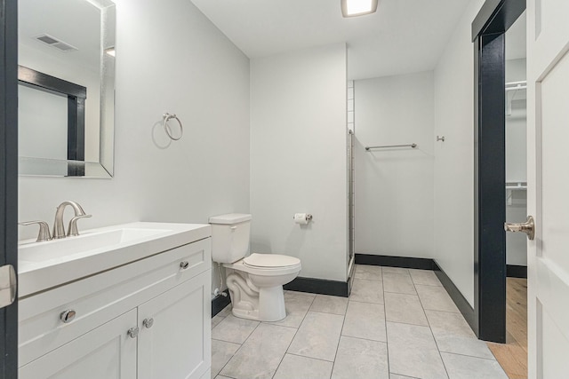 bathroom with tile patterned flooring, vanity, and toilet