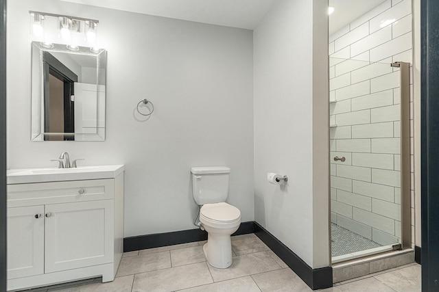 bathroom featuring toilet, tile patterned flooring, tiled shower, and vanity