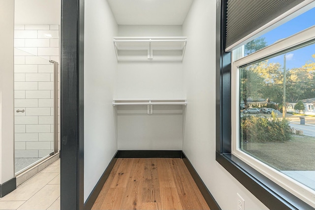 walk in closet with light wood-type flooring