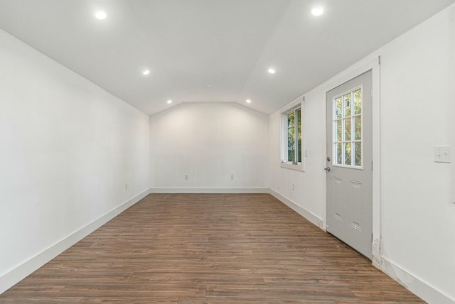 empty room with vaulted ceiling and dark hardwood / wood-style floors