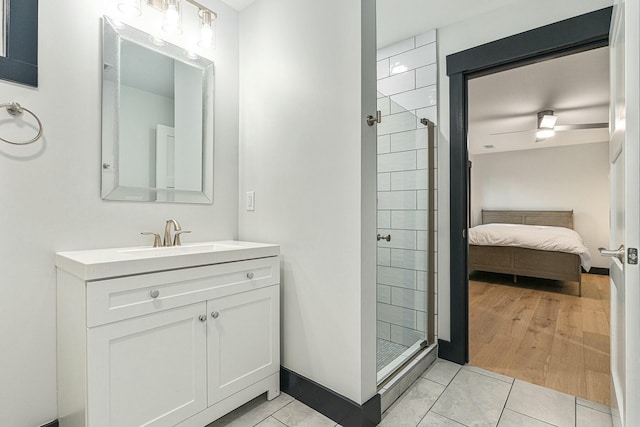 bathroom with tiled shower, tile patterned flooring, and vanity