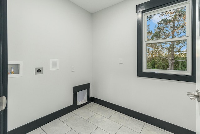 laundry area with electric dryer hookup, light tile patterned flooring, and washer hookup