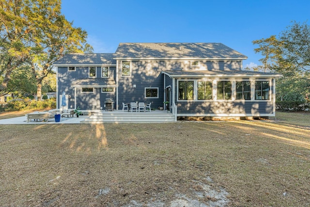 back of property featuring a yard, a sunroom, and a patio