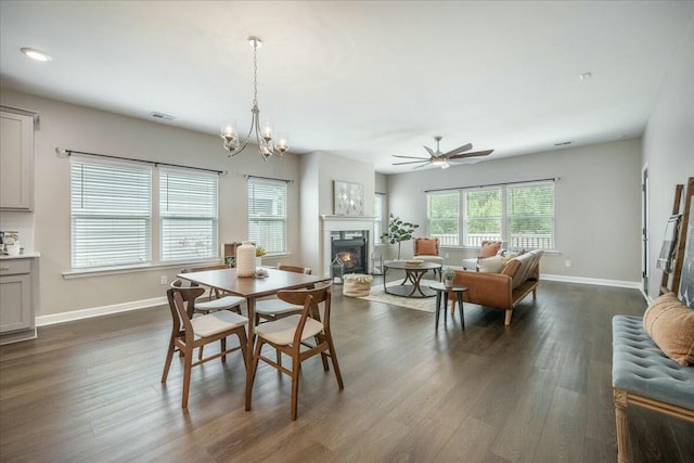 221 Lucca Dr, Summerville, SC 29486 - dining area with visible vents, baseboards, a lit fireplace, dark wood-style flooring, and ceiling fan with notable chandelier