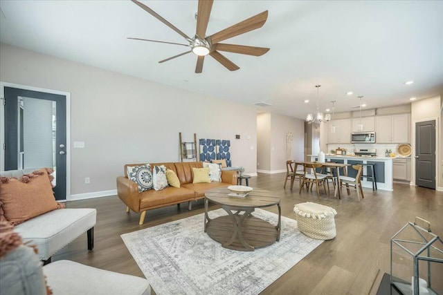 221 Lucca Dr, Summerville, SC 29486 - living area with ceiling fan with notable chandelier, baseboards, dark wood-type flooring, visible vents, and recessed lighting