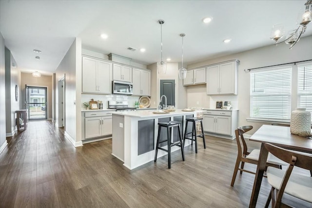 221 Lucca Dr, Summerville, SC 29486 - kitchen featuring dark wood-style flooring, tasteful backsplash, stainless steel appliances, and light countertops