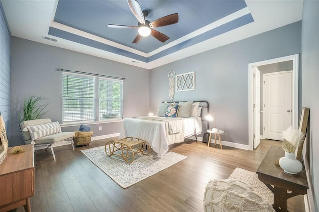 221 Lucca Dr, Summerville, SC 29486 - bedroom with a tray ceiling, visible vents, baseboards, a ceiling fan, and wood finished floors