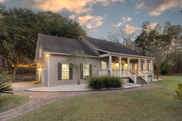 rear view of house featuring decorative driveway, a lawn, covered porch, and a shingled roof