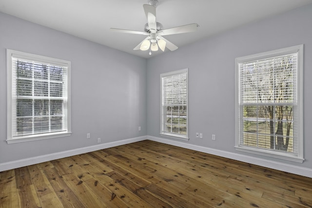 unfurnished room with hardwood / wood-style flooring, a ceiling fan, and baseboards