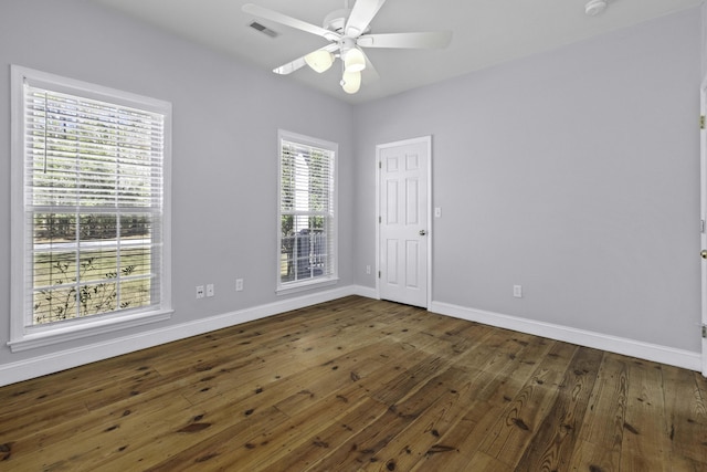 empty room with visible vents, a ceiling fan, baseboards, and wood-type flooring