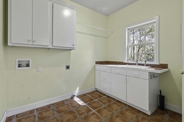 laundry area featuring electric dryer hookup, dark tile patterned floors, a sink, cabinet space, and hookup for a washing machine