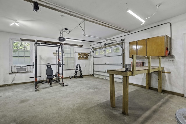 garage featuring cooling unit, baseboards, and a garage door opener