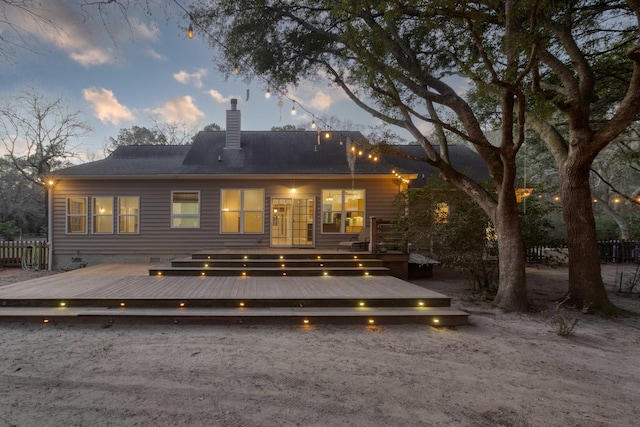 rear view of house with crawl space, a chimney, a deck, and fence