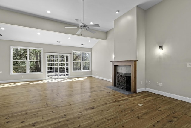 unfurnished living room with recessed lighting, a tile fireplace, baseboards, and hardwood / wood-style flooring