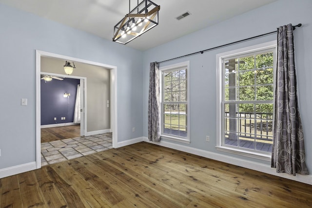 unfurnished dining area with hardwood / wood-style floors, baseboards, and visible vents