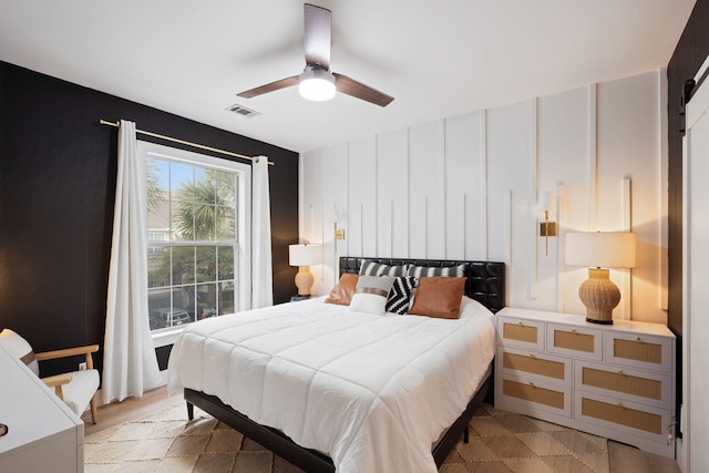 bedroom featuring a barn door and ceiling fan