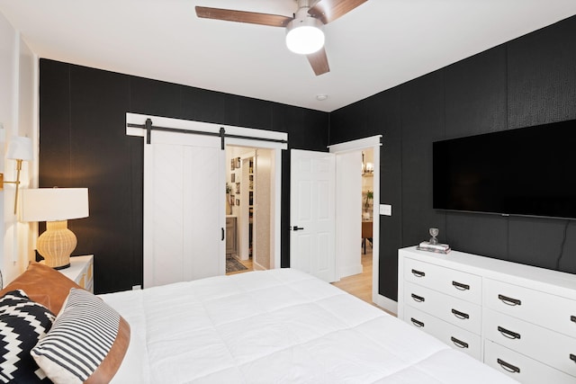 bedroom featuring a barn door and ceiling fan