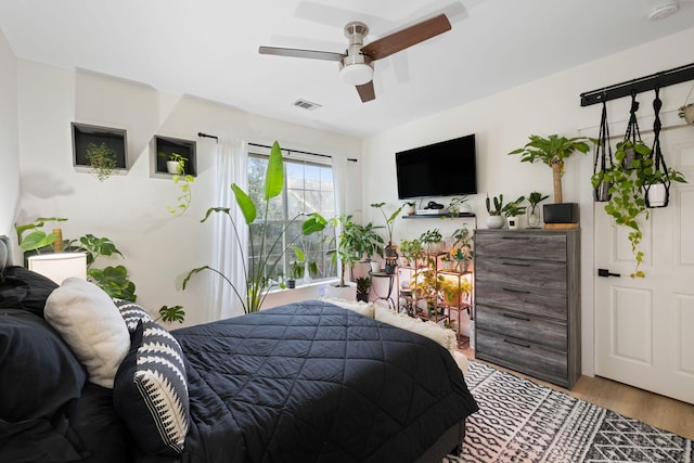 bedroom with light hardwood / wood-style floors and ceiling fan