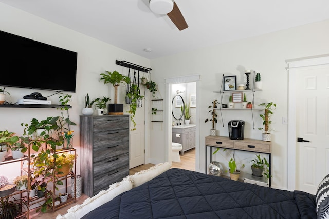 bedroom with ensuite bathroom, light hardwood / wood-style flooring, and ceiling fan