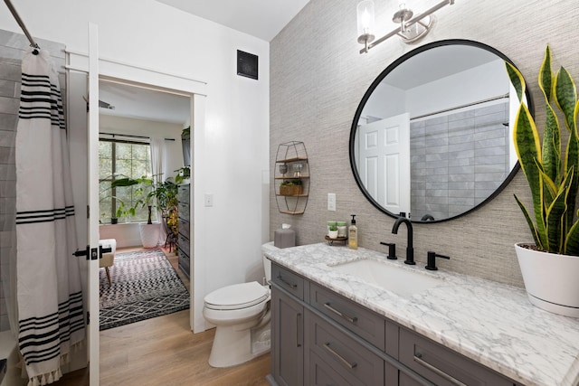 bathroom with wood-type flooring, vanity, and toilet