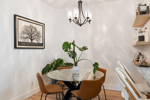 dining space featuring an inviting chandelier and light hardwood / wood-style flooring