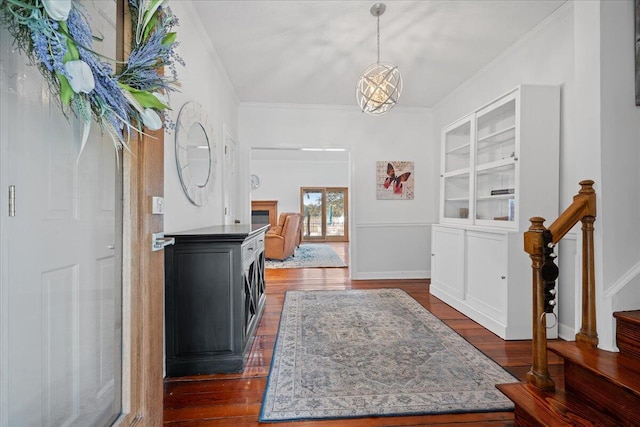 entryway featuring baseboards, dark wood-type flooring, stairway, and crown molding