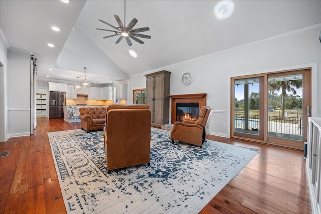 living room featuring baseboards, visible vents, a glass covered fireplace, dark wood-style floors, and ornamental molding