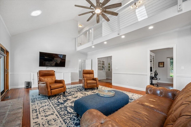 living room with crown molding, recessed lighting, a ceiling fan, high vaulted ceiling, and hardwood / wood-style flooring