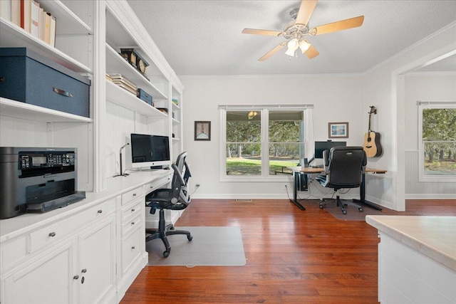 office featuring dark wood-style floors, ceiling fan, baseboards, and crown molding