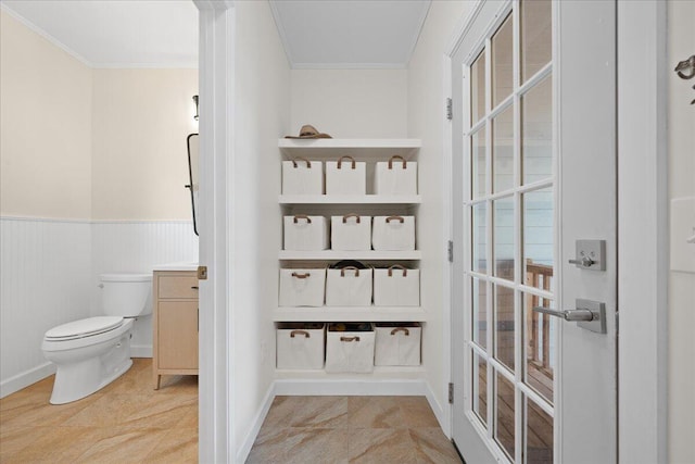 interior space with ornamental molding, wainscoting, and light tile patterned flooring