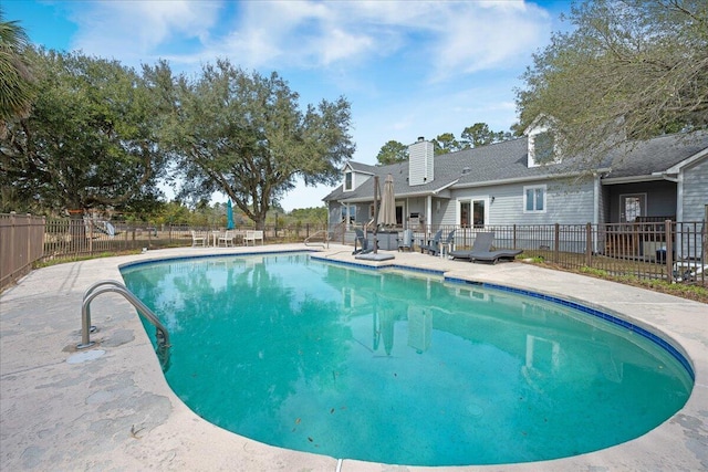 view of swimming pool featuring a patio area, fence, and a fenced in pool