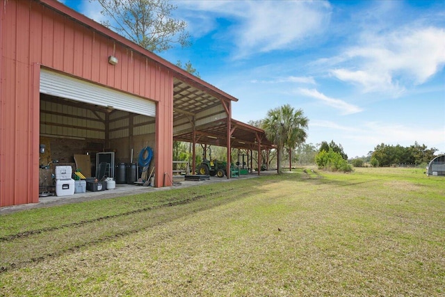 view of yard with a garage, a pole building, and an outbuilding