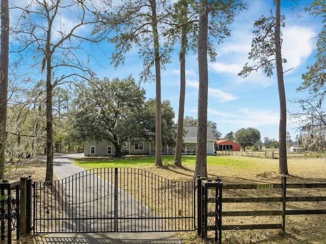 view of gate with fence and a lawn