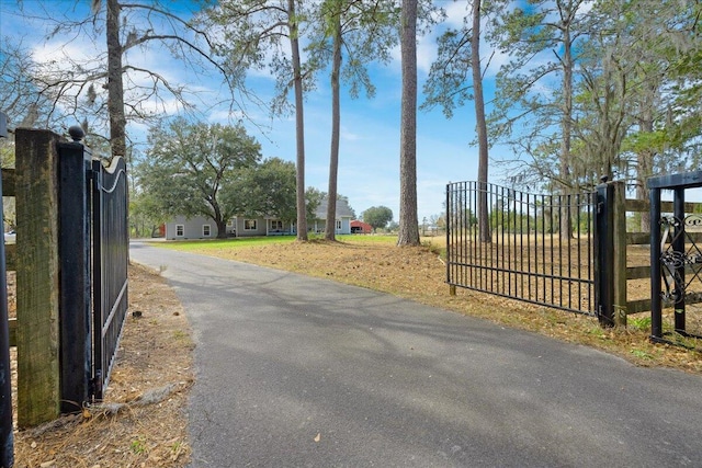 view of street featuring a gate, a gated entry, and aphalt driveway