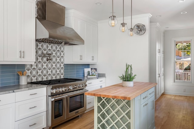 517 Royall Ave, Mount Pleasant, SC 29464 - kitchen with double oven range, butcher block counters, wall chimney exhaust hood, light wood-type flooring, and white cabinets