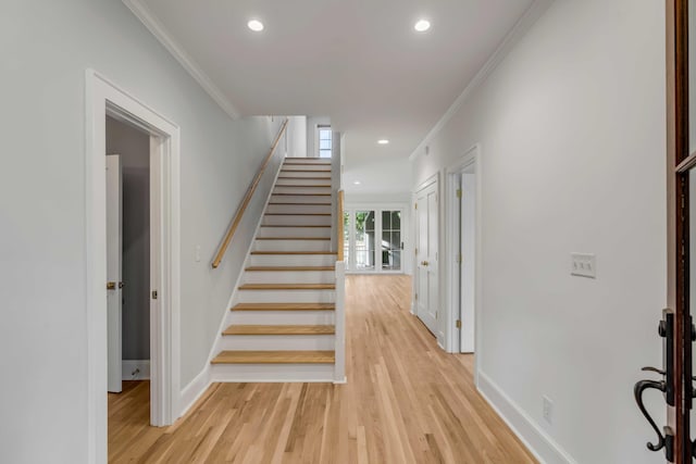 staircase featuring crown molding and hardwood / wood-style flooring